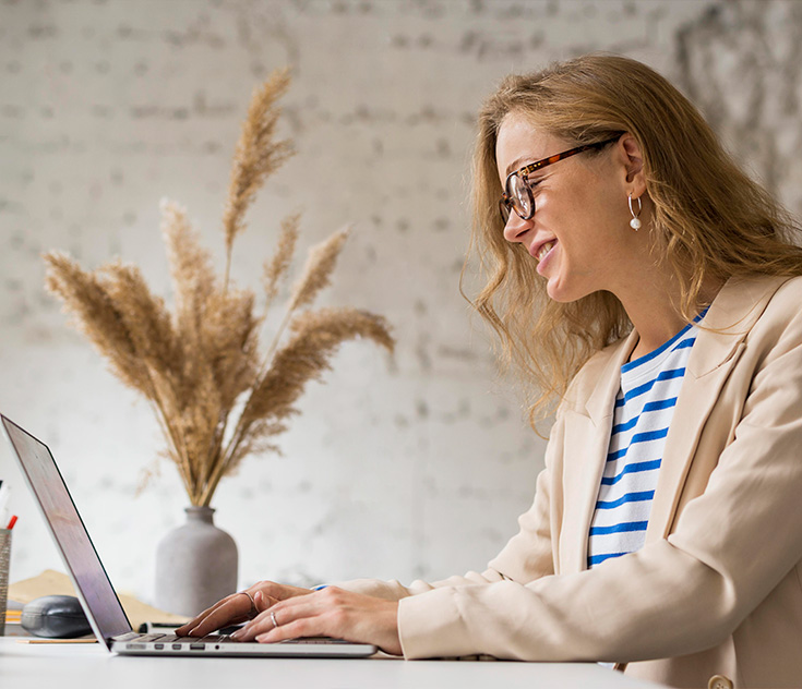 Autora sorrindo ao lado de livros